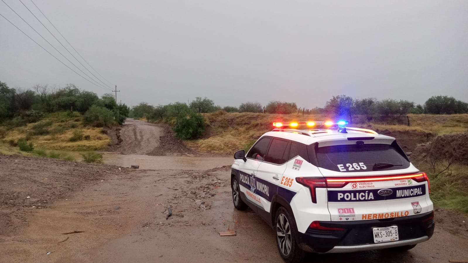 Agentes de la Policía Municipal de Hermosillo brindan apoyo a un automovilista cuyo vehículo presentó fallas durante la lluvia, como parte del operativo de auxilio implementado ante las precipitaciones por la depresión tropical Raymond.
